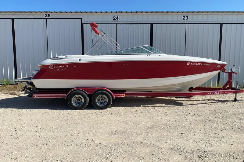 The Image of Red and white Cobalt boat on trailer, parked in front of storage units. - 4