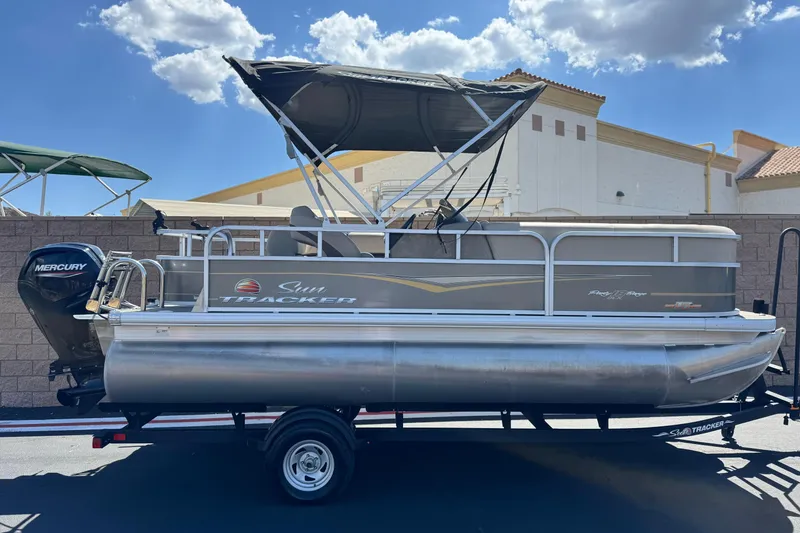 The Image of 2023 Sun Tracker Party Barge 18 DLX pontoon boat with Mercury engine, parked outdoors. - 0