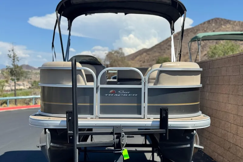 Slide: The Image of 2023 Sun Tracker Party Barge 18 DLX pontoon boat parked with scenic mountain backdrop. - 2