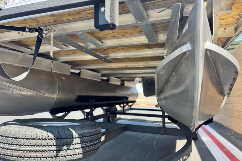 Slide: The Image of Underneath view of 2023 Sun Tracker Party Barge 18 DLX pontoon boat on trailer. - 4