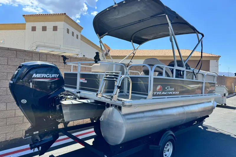 Slide: The Image of 2023 Sun Tracker Party Barge 18 DLX pontoon boat with Mercury engine, parked outdoors. - 6