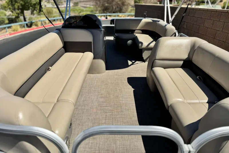 Slide: The Image of 2023 Sun Tracker Party Barge 18 DLX interior with beige seating and spacious layout. - 8