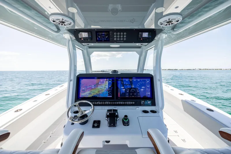 Slide: The Image of 2024 Freeman 43 boat cockpit with advanced navigation screens and steering wheel on open water. - 41
