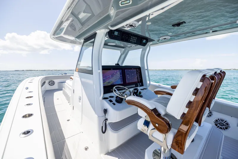 Slide: The Image of 2024 Freeman 43 boat cockpit with advanced navigation system and luxurious seating on open water. - 44