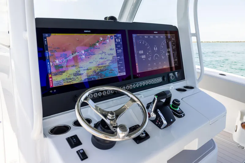 Slide: The Image of 2024 Freeman 43 boat dashboard with dual Simrad displays and steering wheel. - 47