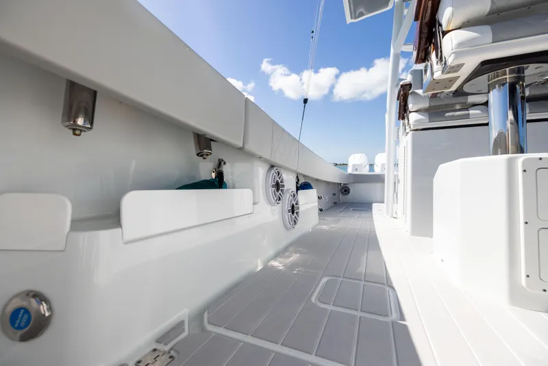 Slide: The Image of 2024 Freeman 43 boat deck with modern seating and sleek design under blue sky. - 70