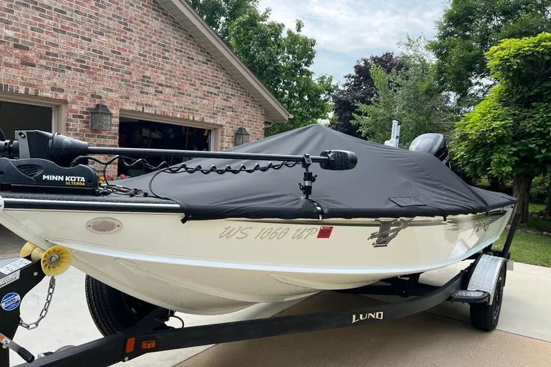 The Image of 2016 Lund 1875 Pro-V Bass XS boat with cover on trailer, parked in driveway. - 0