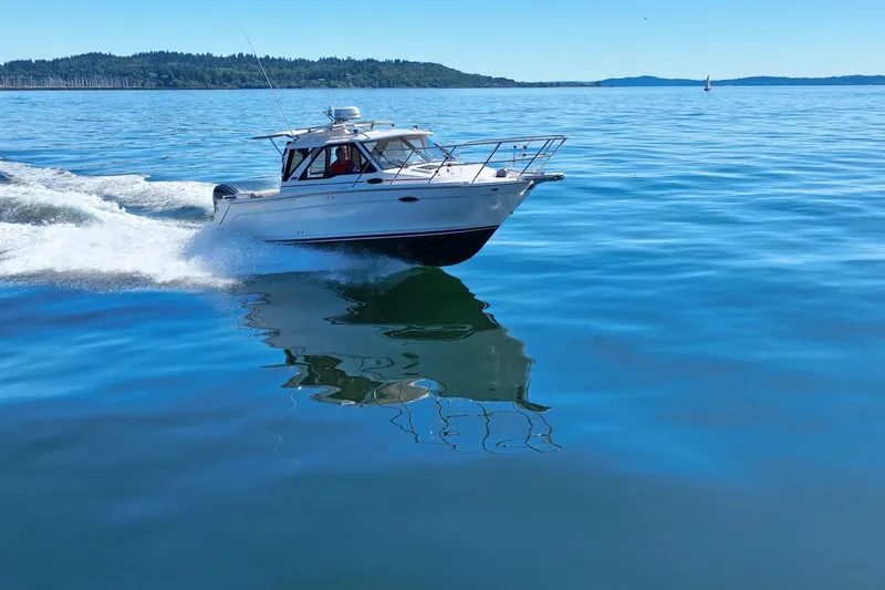 Slide: The Image of 2024 Cutwater C-248 Coupe cruising on open water, rear view with powerful outboard motor. - 10