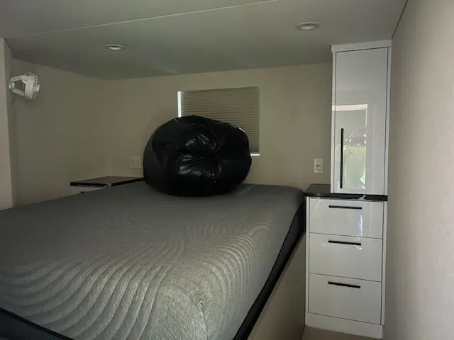 Slide: The Image of Interior of 2023 Adonia Ovation RV with bed and storage cabinet. - 8