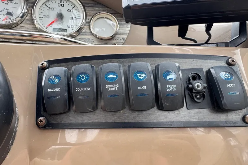 Slide: The Image of Dashboard switches on a 2015 Stingray 215 LR boat, including nav, courtesy, and bilge controls. - 10
