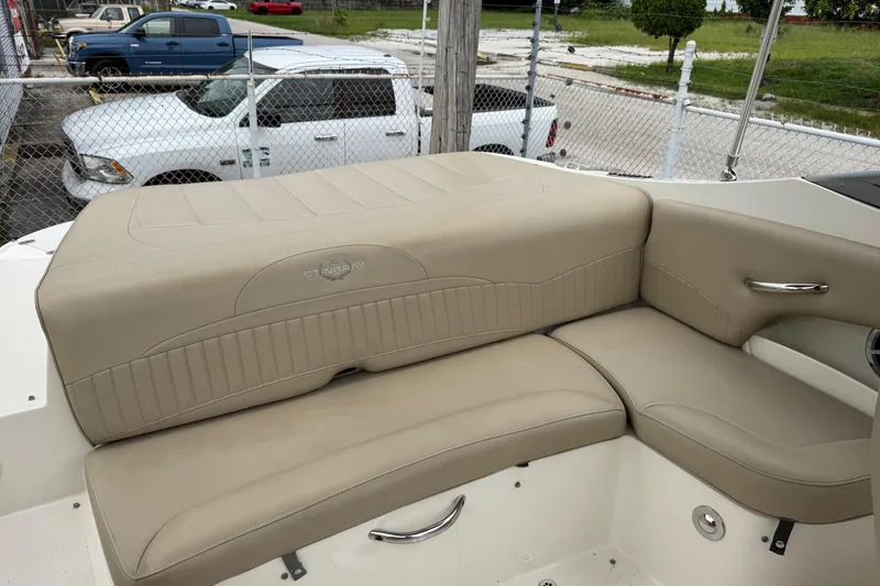 Slide: The Image of 2015 Stingray 215 LR boat interior with beige seating and chrome accents. - 18