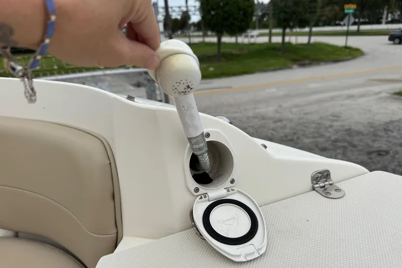 Slide: The Image of Hand operating a fuel cap on a 2015 Stingray 215 LR boat. - 29