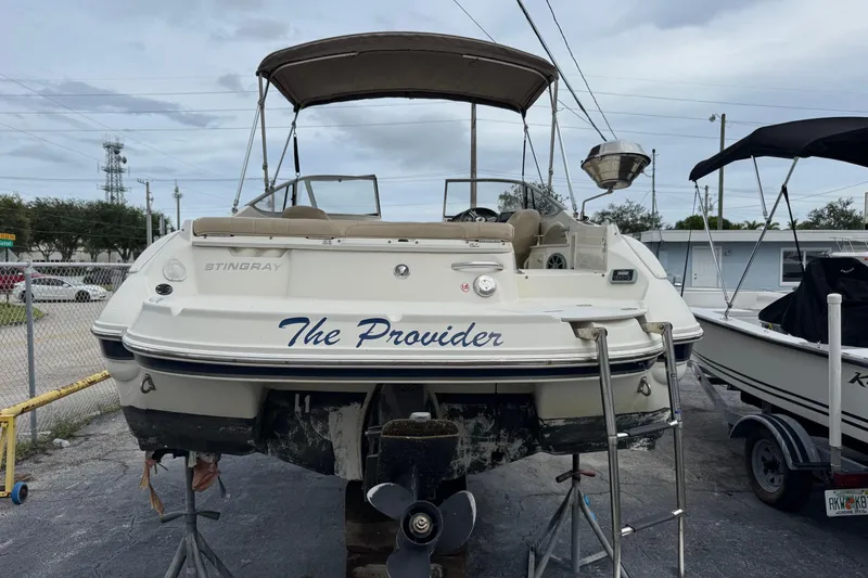 Slide: The Image of 2015 Stingray 215 LR boat named "The Provider" on a trailer in a parking lot. - 3