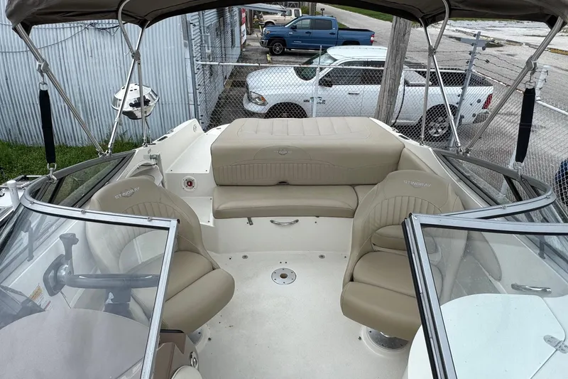 Slide: The Image of 2015 Stingray 215 LR boat interior with beige seating and steering wheel. - 7
