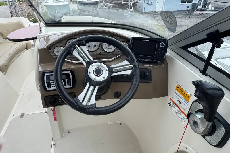 Slide: The Image of 2015 Stingray 215 LR boat dashboard with steering wheel and navigation controls. - 8