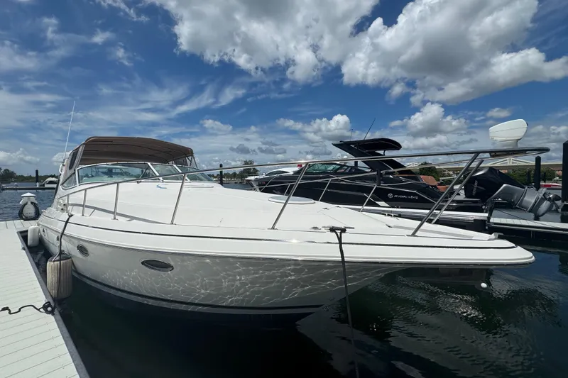 Slide: The Image of 2003 Cruisers Yachts 3372 Express interior with seating and table, dockside view. - 11