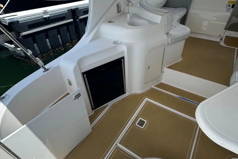 Slide: The Image of 2003 Cruisers Yachts 3372 Express interior with seating and table, featuring tan flooring. - 8