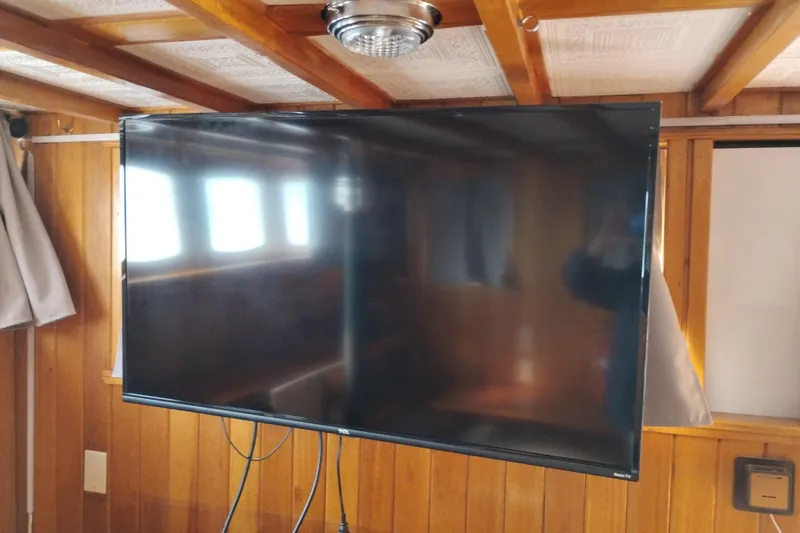 Slide: The Image of Flat-screen TV mounted on wooden wall inside 1983 Custom Entienne Francois 50 Pilothouse. - 12