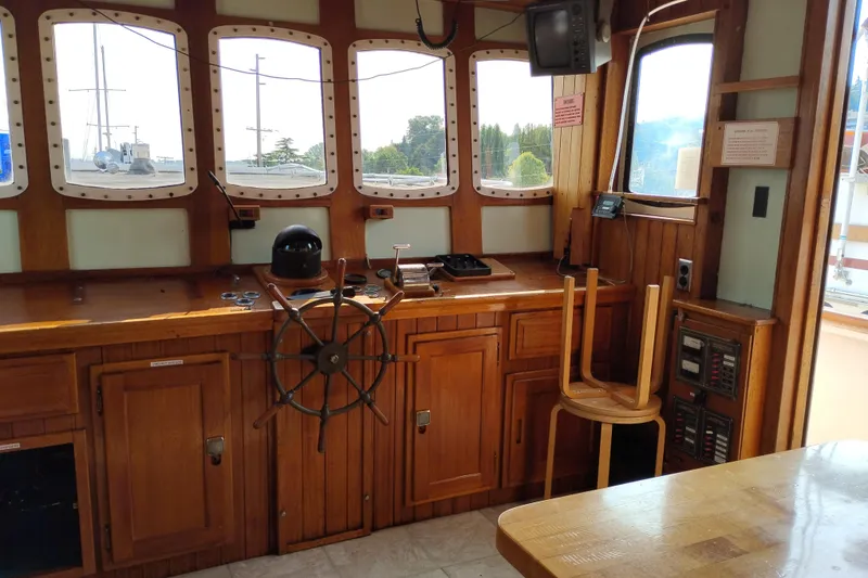 Slide: The Image of Pilothouse interior of 1983 Custom Entienne Francois 50, featuring wooden helm and navigation equipment. - 15
