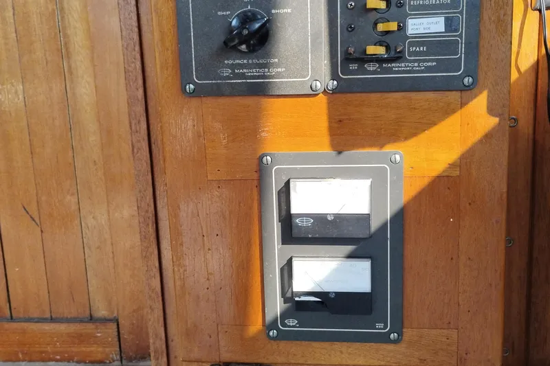 Slide: The Image of Control panel on 1983 Custom Entienne Francois 50 Pilothouse, featuring switches and gauges. - 19