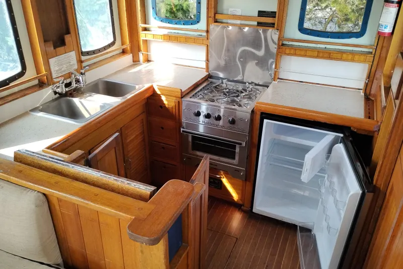 Slide: The Image of 1983 Custom Entienne Francois 50 Pilothouse kitchen with stove, sink, and open fridge. - 23
