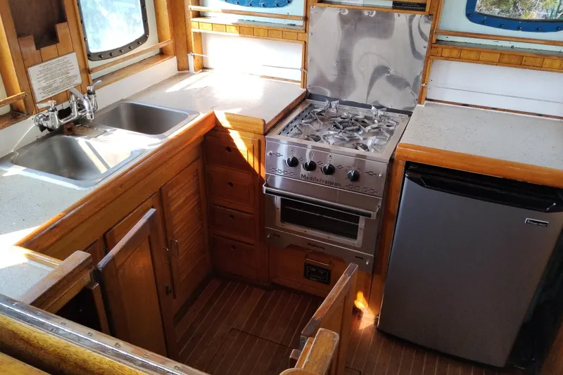 Slide: The Image of 1983 Custom Entienne Francois 50 Pilothouse kitchen with stove, sink, and fridge. - 26
