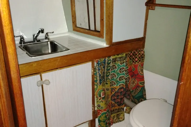 Slide: The Image of Vintage 1983 Custom Entienne Francois 50 Pilothouse bathroom with sink and colorful curtain. - 32