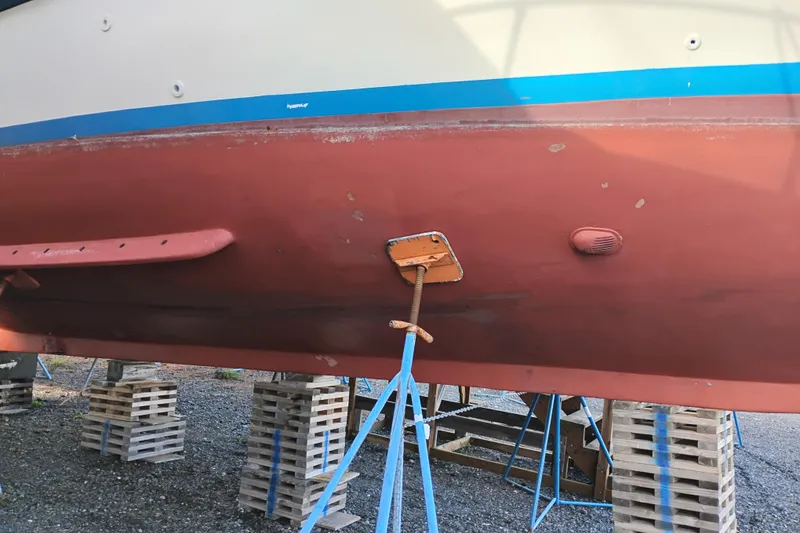 Slide: The Image of 1983 Custom Entienne Francois 50 Pilothouse boat hull on stands, showing red and blue paint. - 48