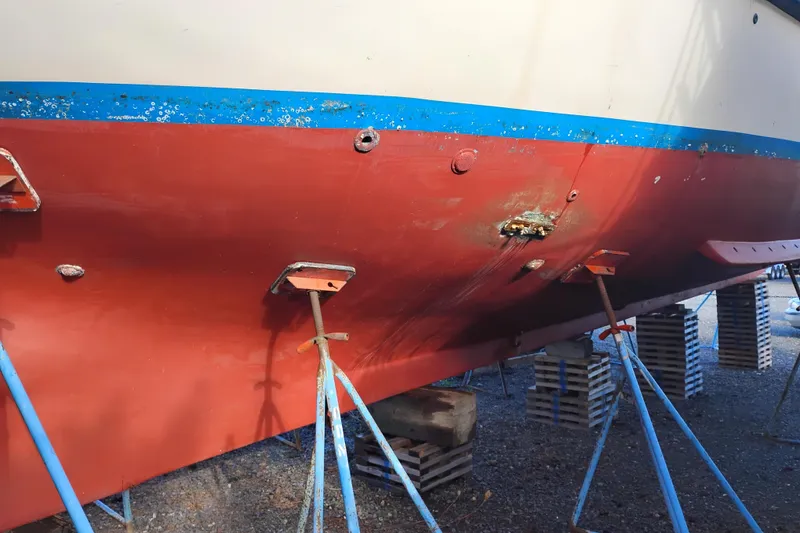 Slide: The Image of Red and blue hull of 1983 Custom Entienne Francois 50 Pilothouse on stands. - 51