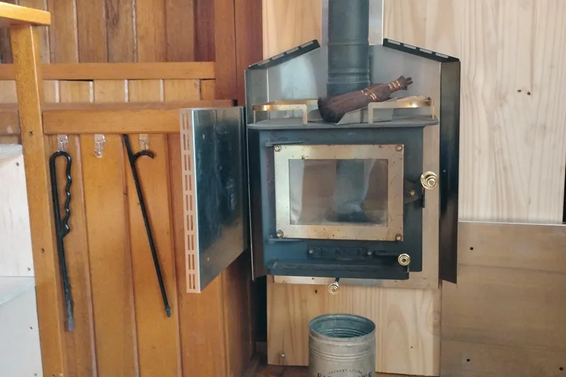 Slide: The Image of Wood-burning stove inside 1983 Custom Entienne Francois 50 Pilothouse, with tools and metal bucket. - 8