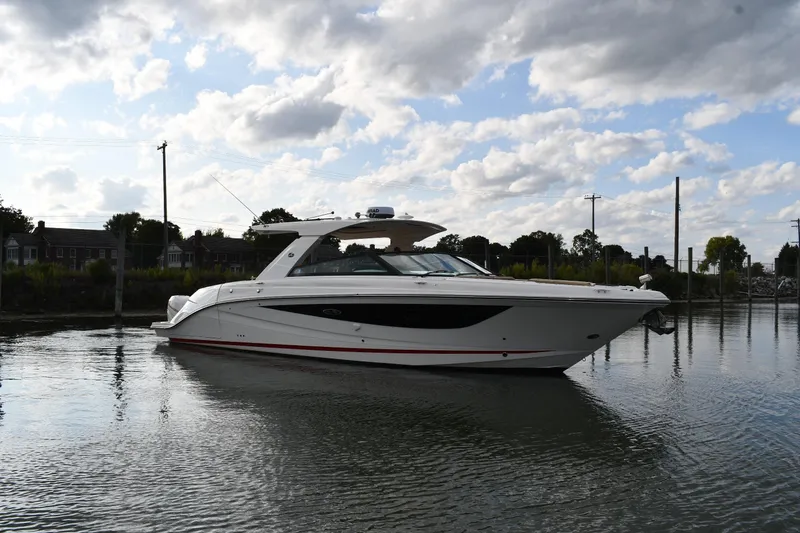Slide: The Image of 2020 Sea Ray SLX 400 Outboard boat on calm water under a cloudy sky. - 0
