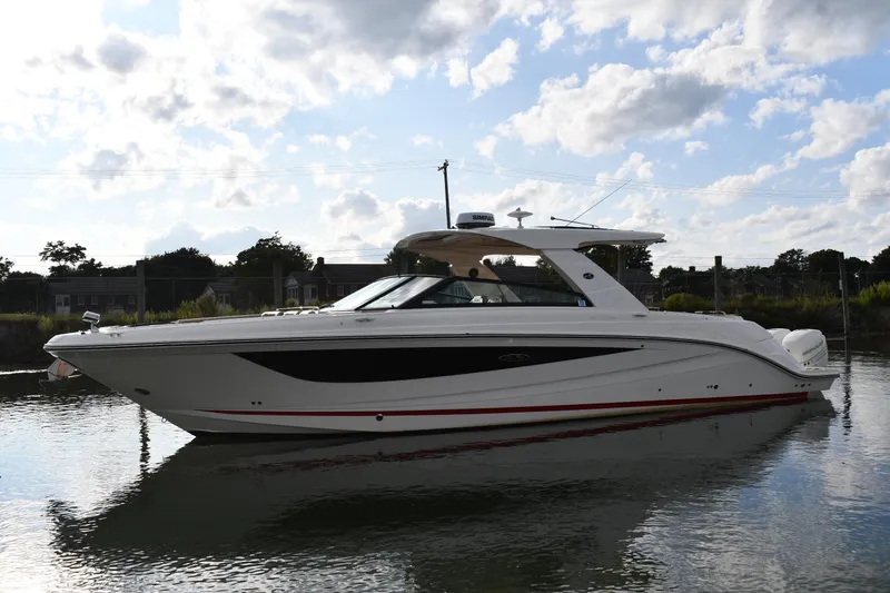Slide: The Image of 2020 Sea Ray SLX 400 Outboard boat on calm water under a partly cloudy sky. - 1