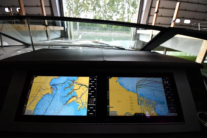 Slide: The Image of Dashboard of 2020 Sea Ray SLX 400 Outboard with navigation screens in a marina setting. - 14