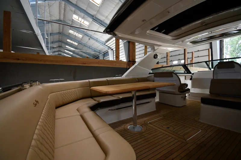 Slide: The Image of 2020 Sea Ray SLX 400 Outboard interior with luxurious seating and wooden table. - 19