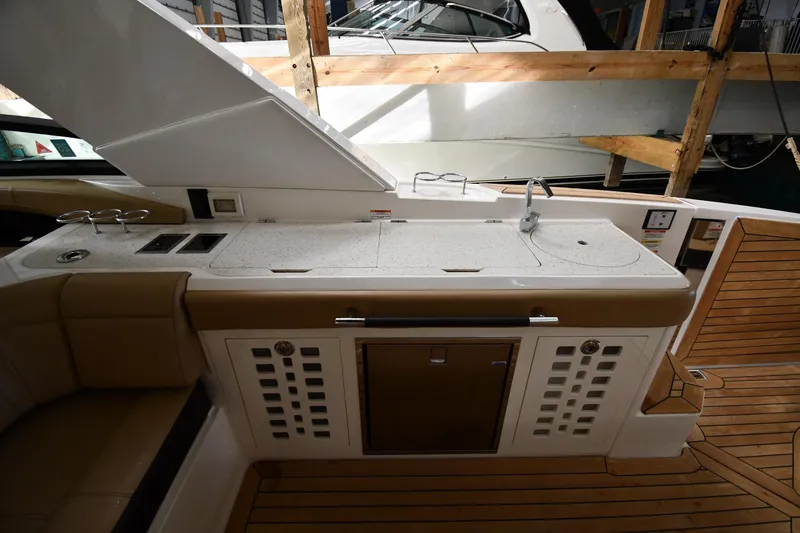 Slide: The Image of 2020 Sea Ray SLX 400 Outboard boat interior with kitchenette and wooden flooring. - 22