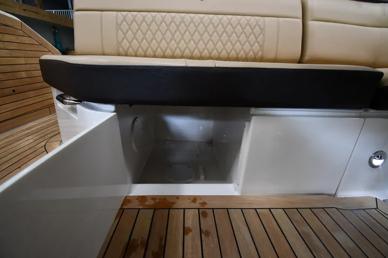 Slide: The Image of 2020 Sea Ray SLX 400 Outboard storage compartment with beige seating and wooden deck. - 26