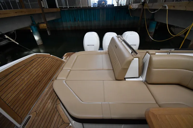 Slide: The Image of 2020 Sea Ray SLX 400 Outboard with tan seating and wooden deck in a marina. - 29