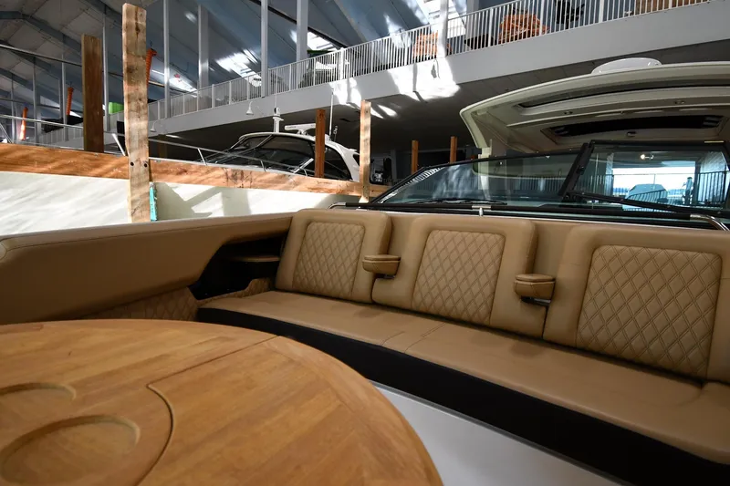 Slide: The Image of Luxurious interior of 2020 Sea Ray SLX 400 Outboard with tan seating and wooden table. - 36
