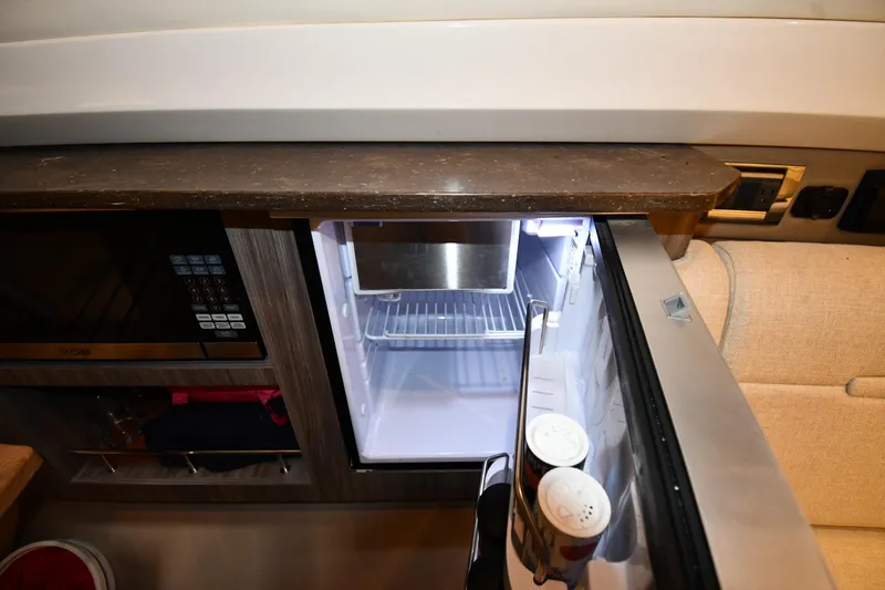 Slide: The Image of Interior of 2020 Sea Ray SLX 400 Outboard with open fridge and microwave. - 57