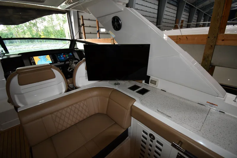 Slide: The Image of Interior of 2020 Sea Ray SLX 400 Outboard with seating, TV, and navigation display. - 65