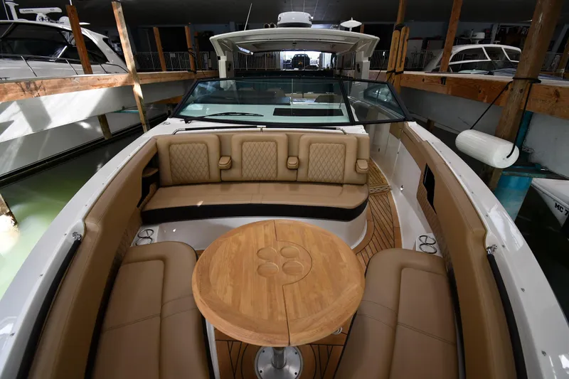 Slide: The Image of 2020 Sea Ray SLX 400 Outboard boat interior with tan seating and wooden table. - 9