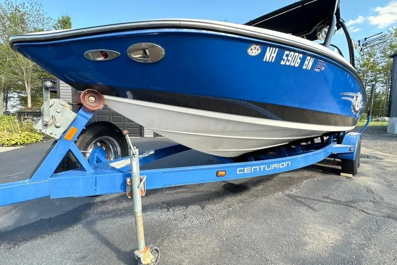 Slide: The Image of 2006 Centurion Enzo SV230 boat on blue trailer, parked outdoors. - 10