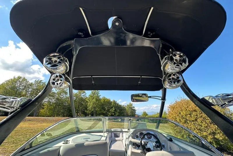 Slide: The Image of 2006 Centurion Enzo SV230 boat interior with speakers and canopy, under a clear blue sky. - 15