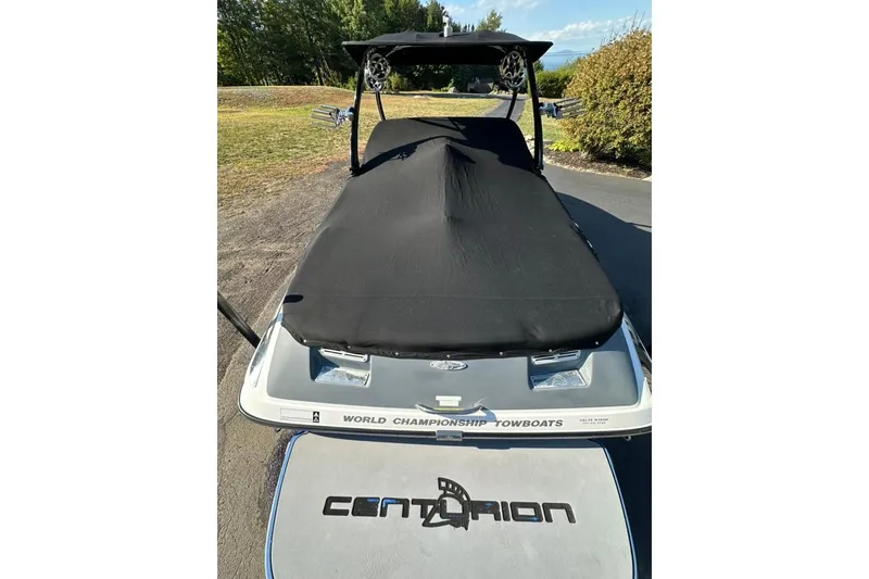 Slide: The Image of 2006 Centurion Enzo SV230 boat with cover, parked on a driveway. - 26
