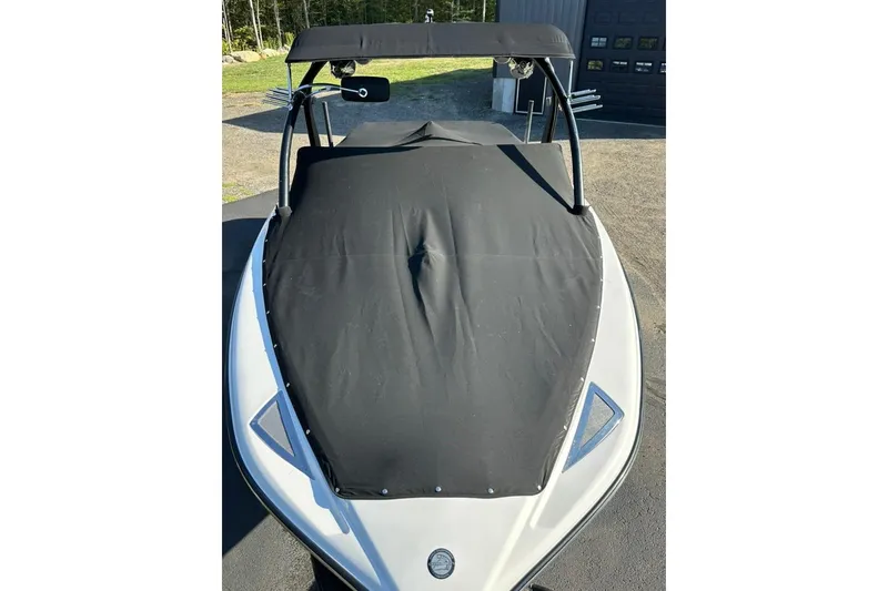 Slide: The Image of 2006 Centurion Enzo SV230 boat with black cover and canopy, parked outdoors. - 27