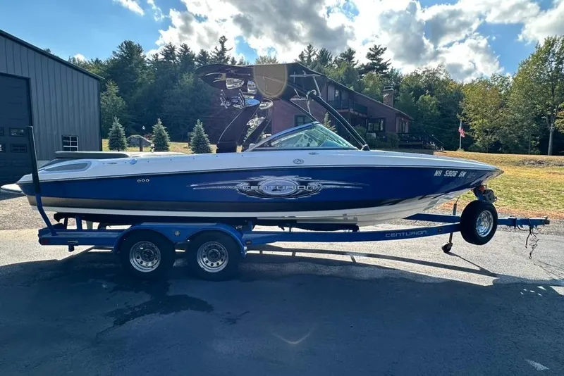 Slide: The Image of 2006 Centurion Enzo SV230 boat on trailer, parked outdoors under a partly cloudy sky. - 5
