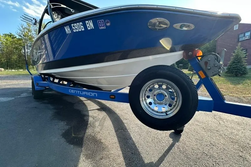 Slide: The Image of 2006 Centurion Enzo SV230 boat on trailer, blue and white, parked outdoors. - 9