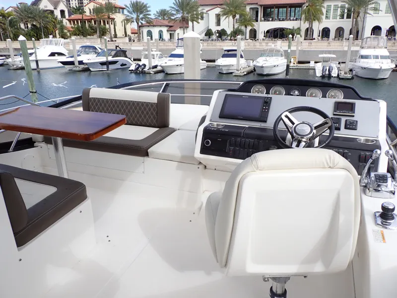 Slide: The Image of 2015 Sea Ray 510 Fly yacht with elegant outdoor seating and dining area at marina. - 24