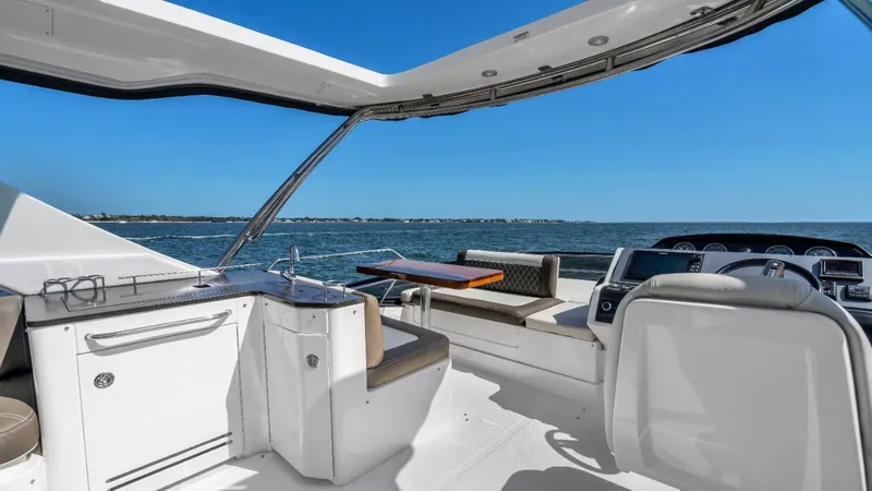 Slide: The Image of 2015 Sea Ray 510 Fly yacht cruising on open water with city skyline in background. - 3