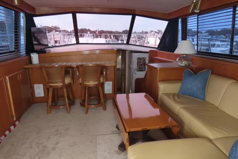 Slide: The Image of Interior of 1987 Bertram 42 Convertible yacht with seating, table, and bar stools. - 11